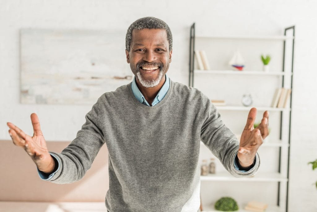 happy african american man looking at camera and showing welcome gesture