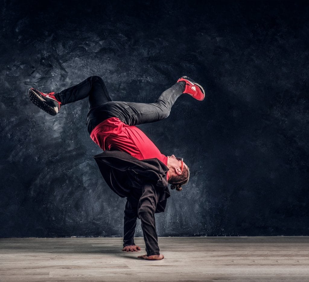 Hip-hop style dancer performs breakdance acrobatic elements.